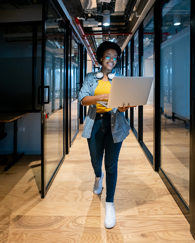 Happy-IT-technician-working-at-the-office-using-her-laptop-800x1000